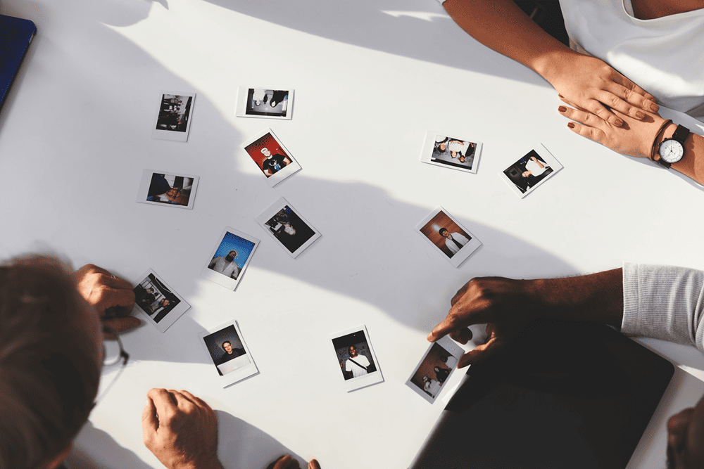 Instax Sofortbild Bilderrahmen Eine Familie sortiert ihre Instax Sofortbilder für Bilderrahmen