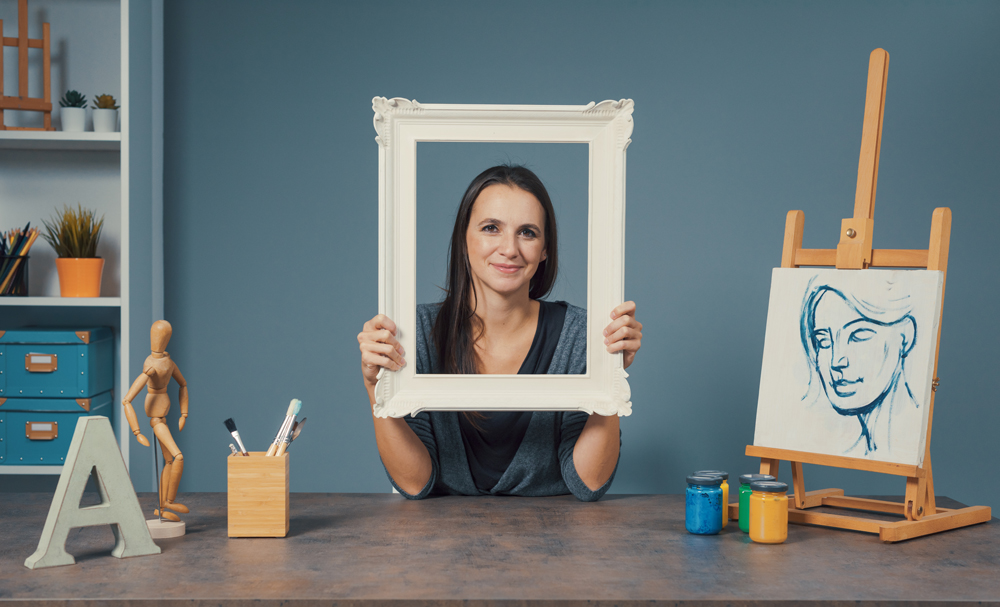 Bilderrahmen mit Portrait Eine Frau hält ein Portrait von sich in den Händen
