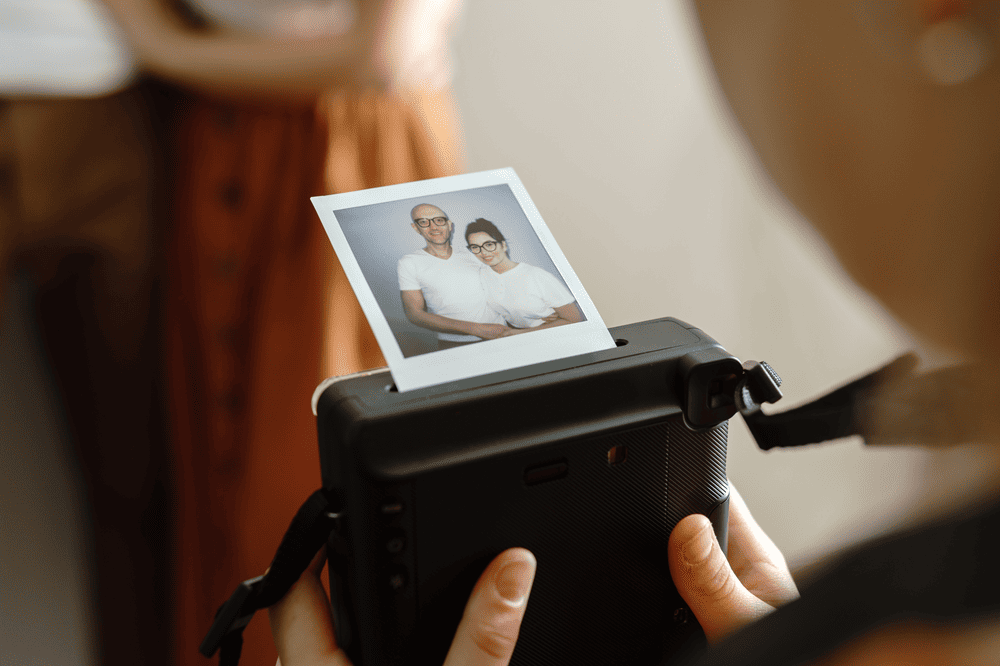 Polaroid Fotos von einem Paar Eine Person macht Polaroid Fotos von einem Pärchen