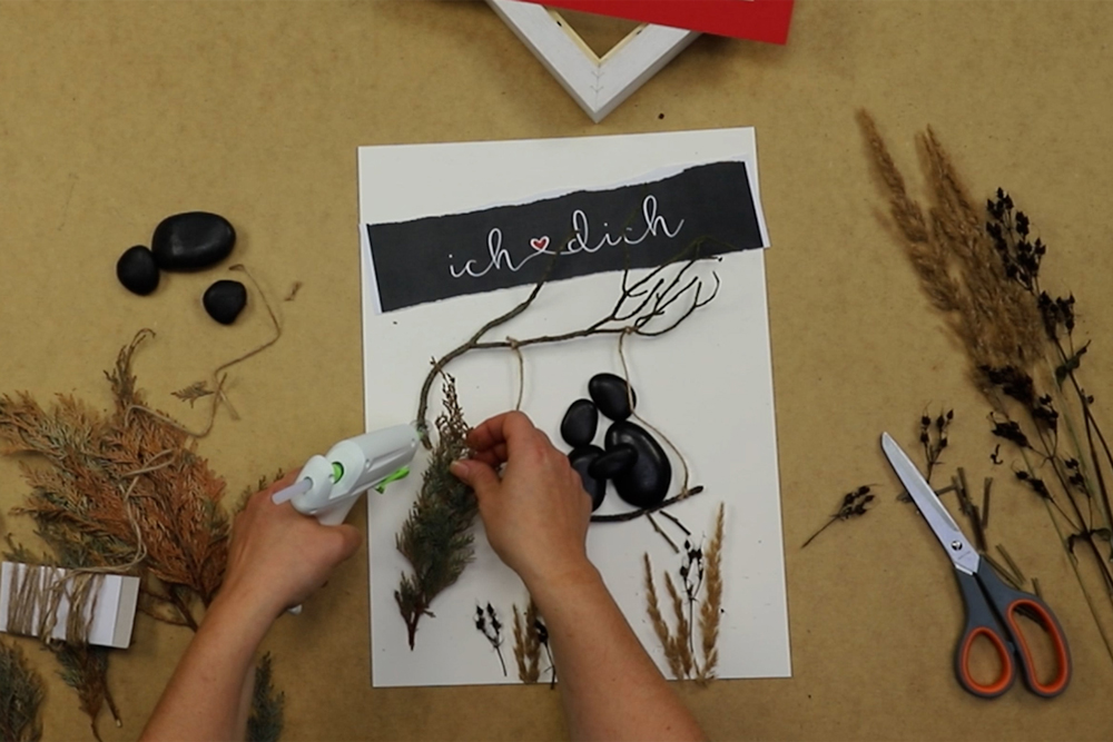 DIY Gerahmtes Steinbild: Kleben Materialien werden für Bastelprojekt angeklebt
