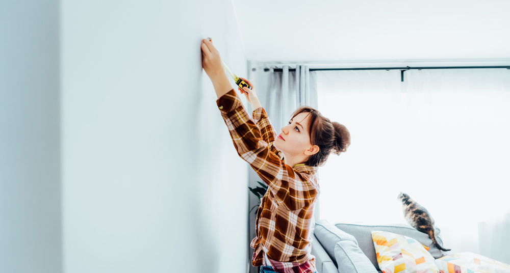 Spiegelaufhängung - Wand ausmessen Wand wird mithilfe eines Maßbandes gemessen