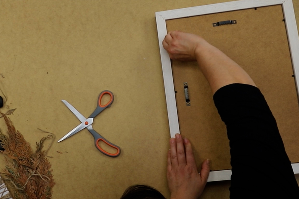 DIY Gerahmtes Steinbild: Motiv Rahmen Bastelprojekt wird mit Passepartout und Abstandsleiste in Bilderrahmen eingelegt