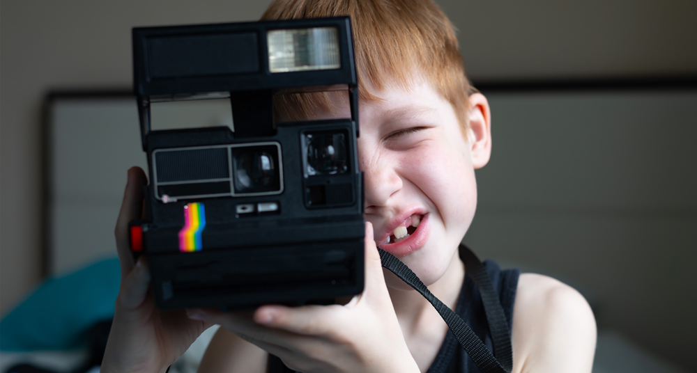 Kind schießt Foto mit Polaroidkamera
