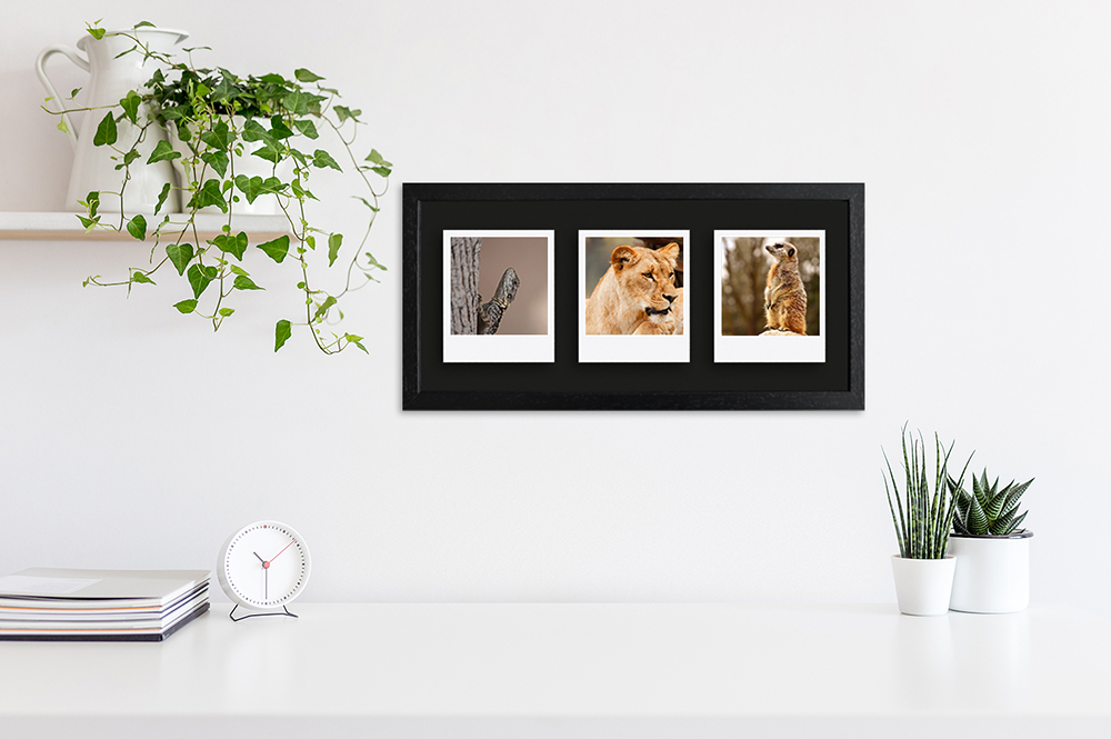 schwarzer Polaroid Rahmen für drei Bilder modern eingerichteter Arbeitsplatz dekoriert mit schwarzem Fotorahmen
