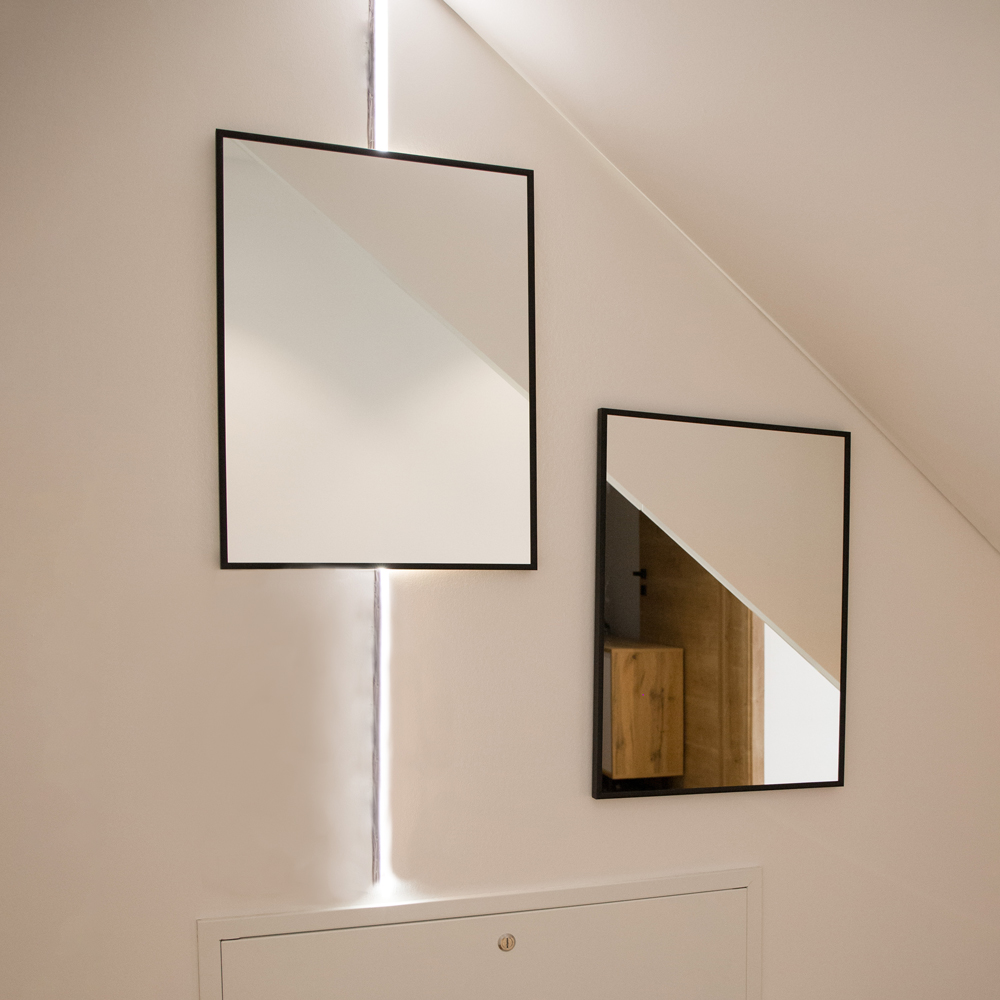 schwarze Wandspiegel werden zusammen mit LED-Band angebracht