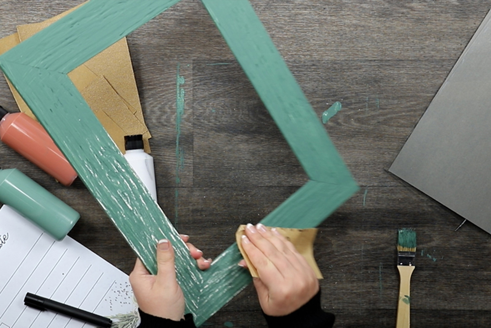 DIY - Shabby Chic Rahmen selbst gemacht: Feinschliff geben grüne Farbe wird von Bilderrahmen per Schleifpapier entfernt