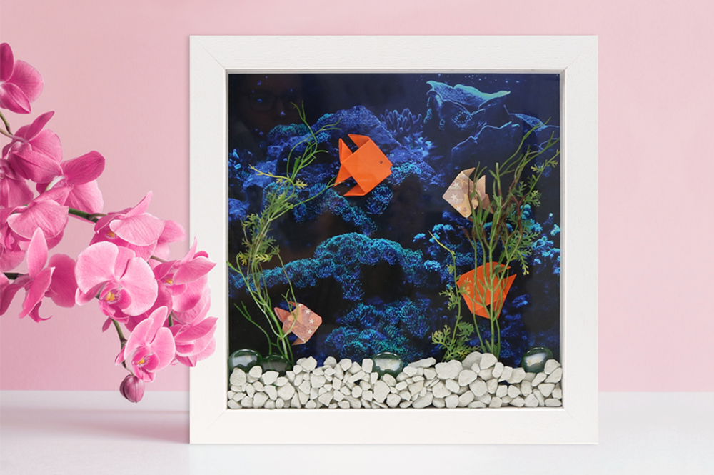Geschenkidee: DIY-Geldaquarium in Objektrahmen zu Fischen gefaltetes Geld in weißem Rahmen