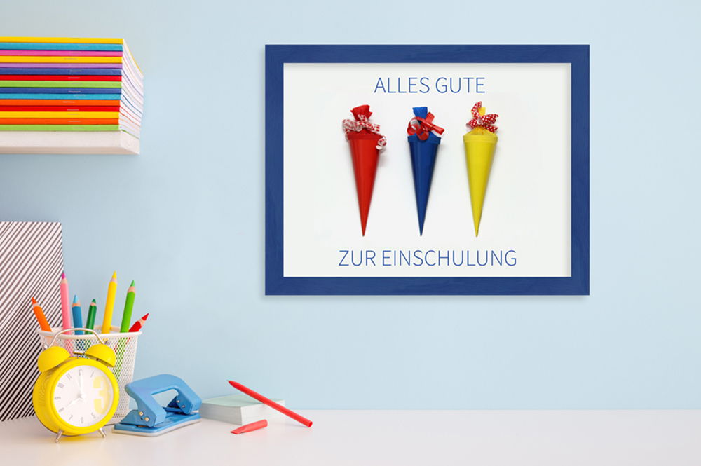Geschenkidee zur Einschulung: eingerahmte Zuckertüte bunt dekorierter Schreibtisch mit blauem Bilderrahmen