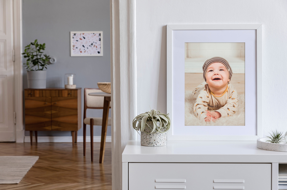 Babyfoto in weißem Bilderrahmen mit hellblauem Passepartout