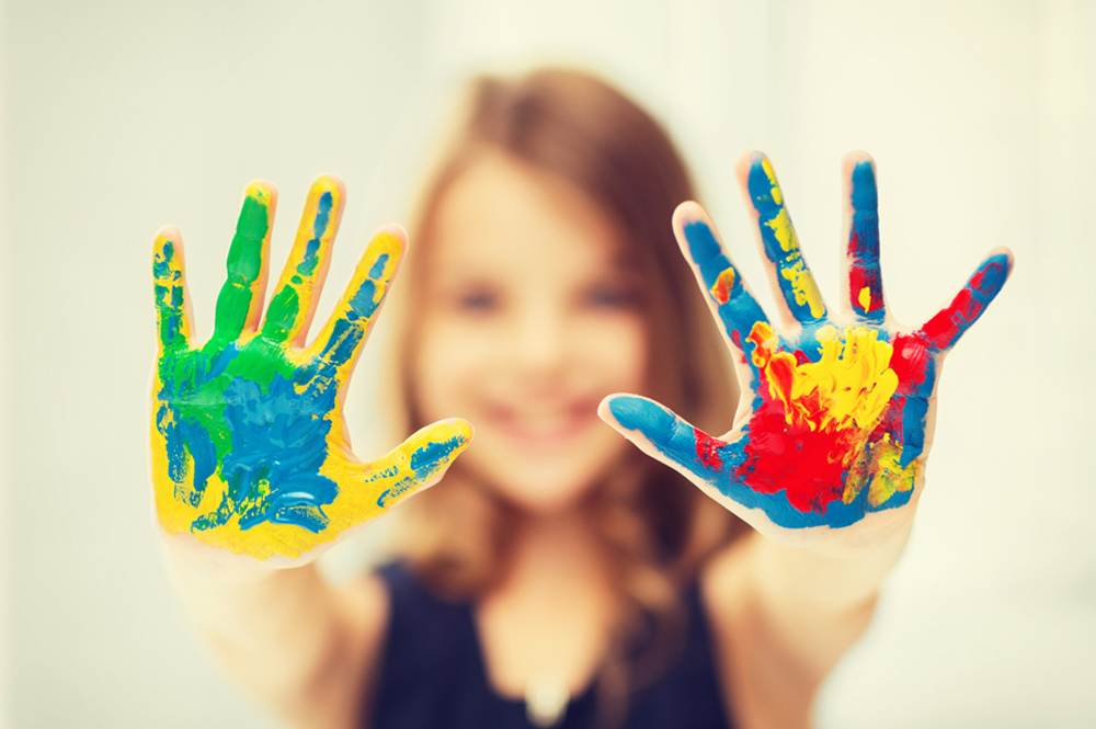 Mädchen mit Händen voller Farbe