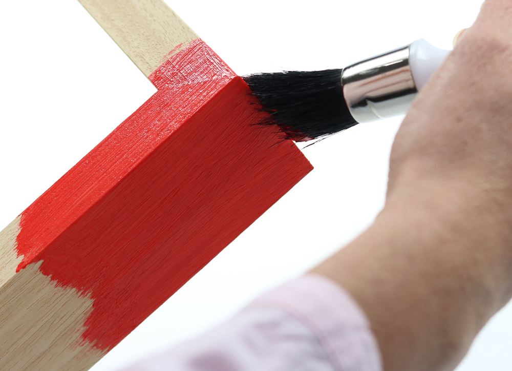 Objektrahmen mit roter Farbe anpinseln unlackierter Objektrahmen wird mit rotem Lack bestrichen