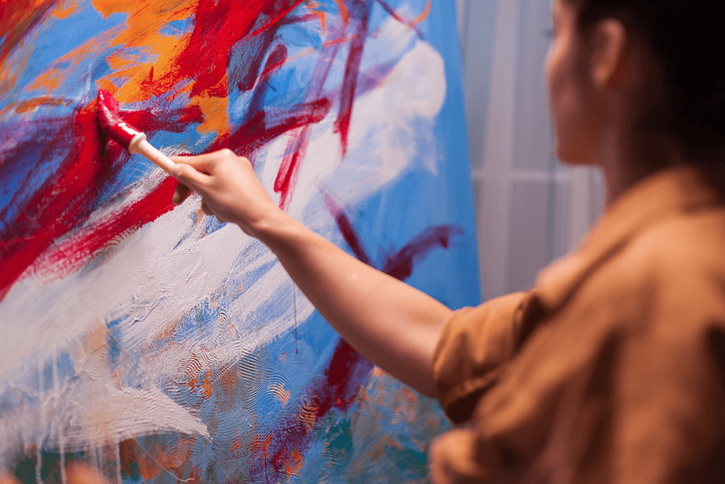 buntes und abstraktes Leinwandbild Frau malt abstraktes Kunstwerk