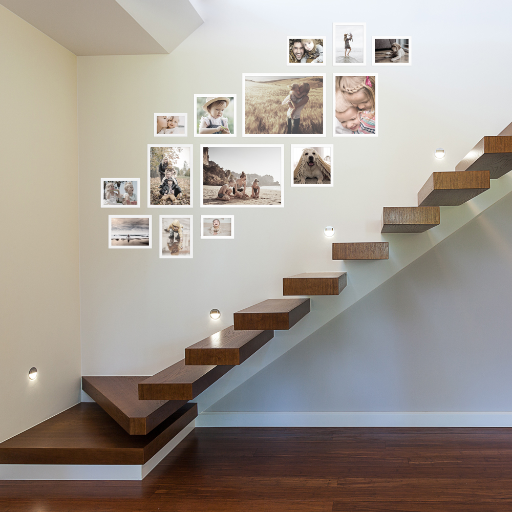 Bilderwand im Treppenhaus aus weißem 14er Bilderrahmen-Set