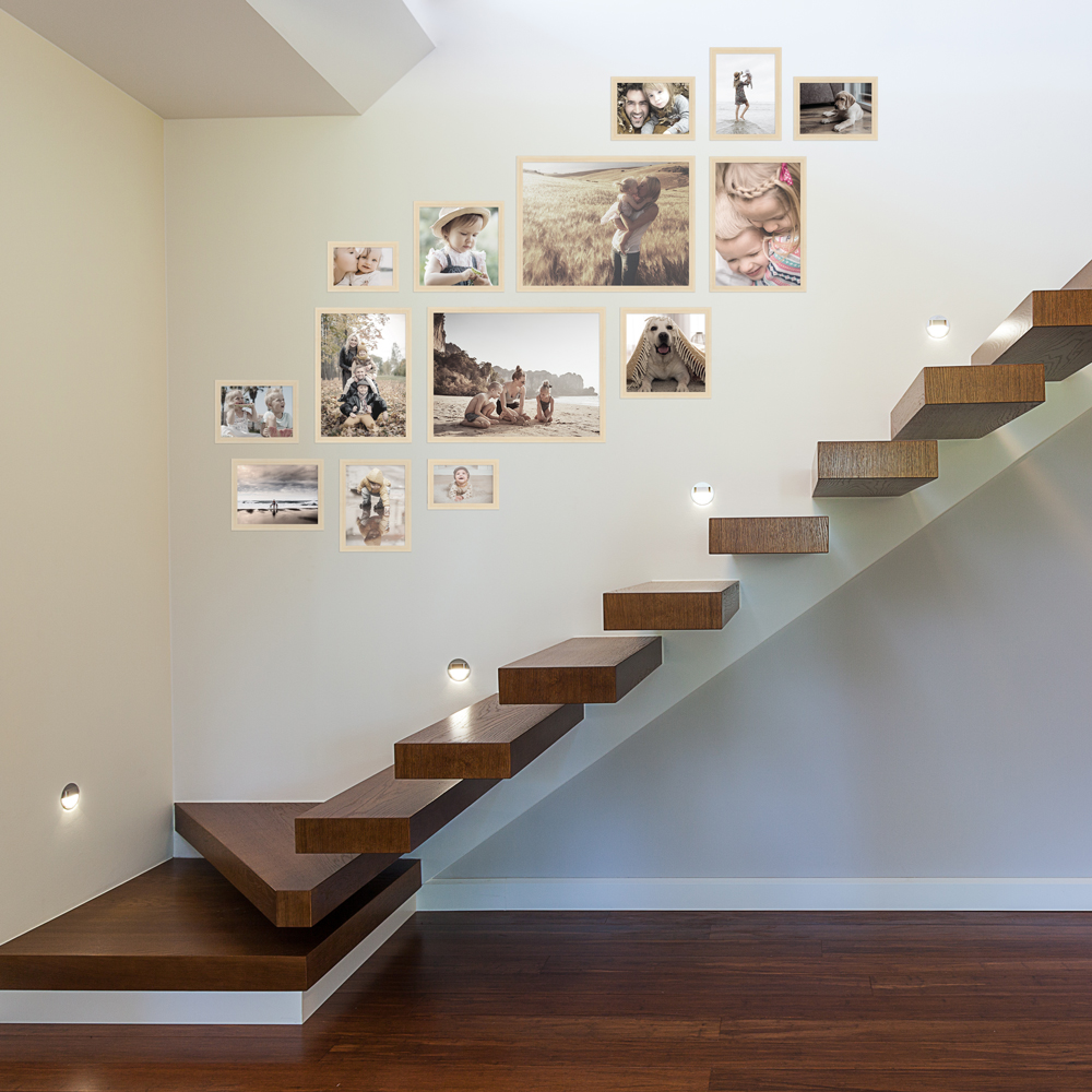 Bilderwand im Treppenhaus aus naturfarbenen 14er Bilderrahmen-Set