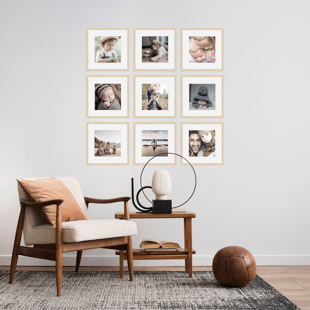 Bilderwand aus naturfarbenen Bilderrahmen mit weißen Passepartouts 
