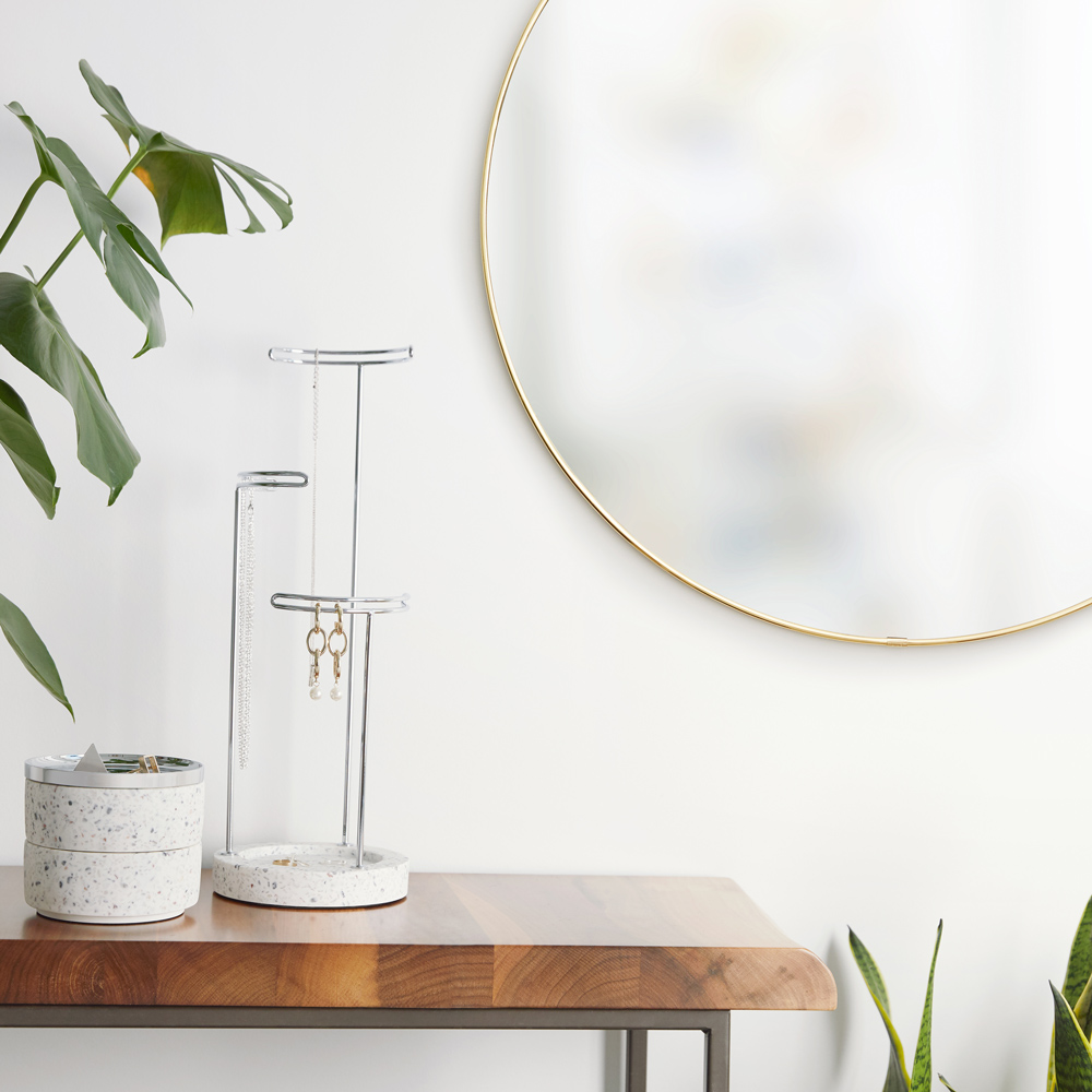 Detailbild - Goldener runder Wandspiegel Goldener runder Spiegel der neben einem Tisch hängt