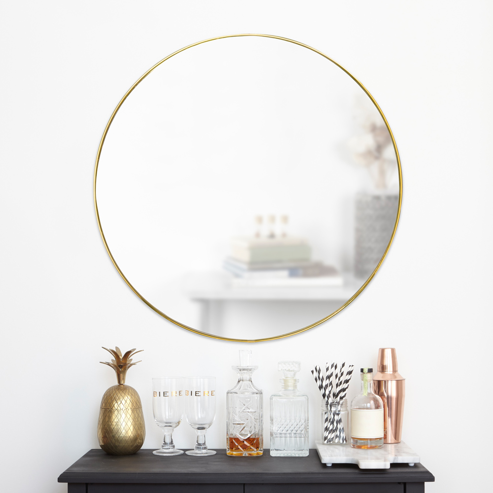 Goldener runder Spiegel der über  Parfüm hängt
