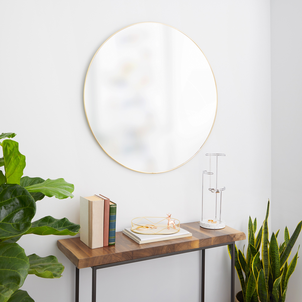 Goldener runder Spiegel zum Aufhängen Goldener runder Spiegel der über einem Regal aufgehängt wurde